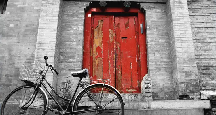 a bike in front of a red door in Hutong