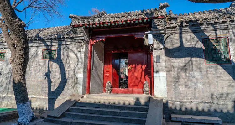 a bike in front of a red door in Hutong