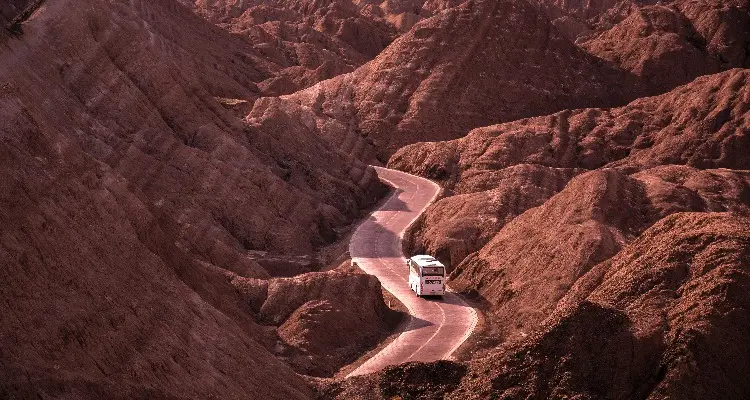 a bus on the road in the red mountains