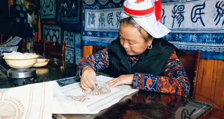 a lady is making batiks