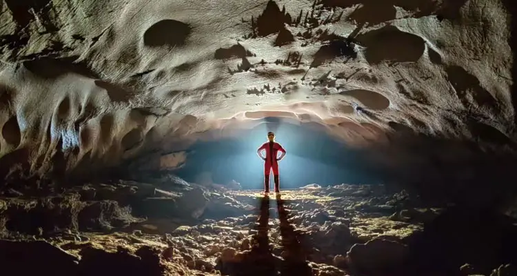 a man in red in the cave