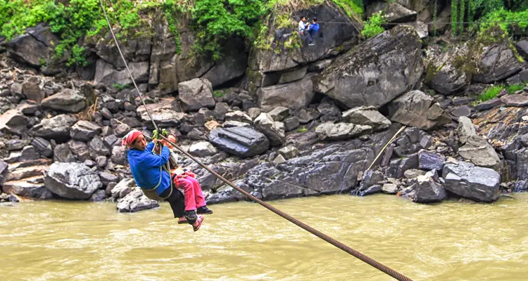 a woman on the zipline across the river